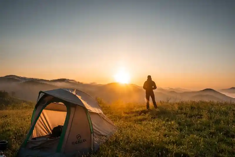 Tente de bivouac en montagne au lever du soleil en France
